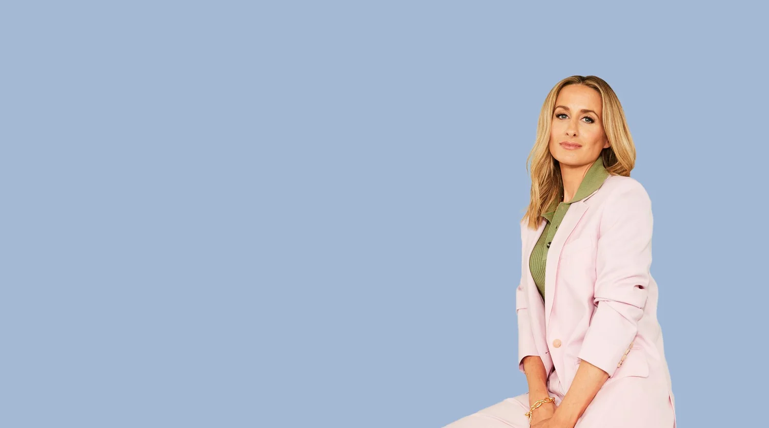 Dr Julie Smith seated in a pink suit against a blue background